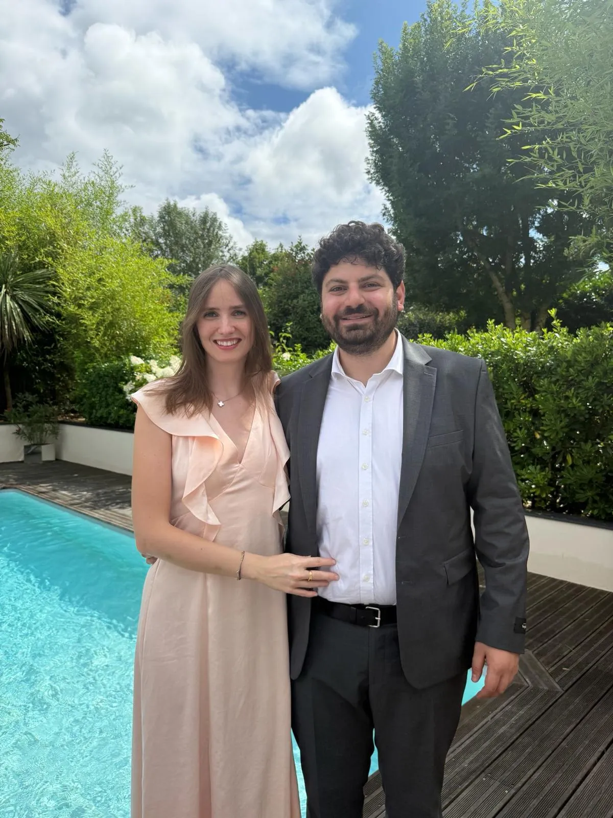 Diane et Mark dans un jardin, robe champagne et costume gris